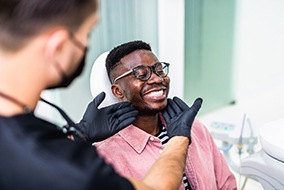Patient smiling while dentist examines his teeth