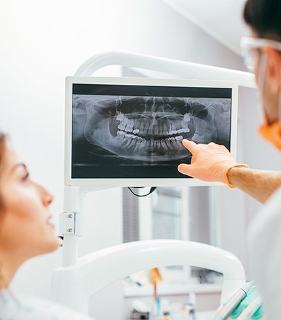 Dentist and patient looking at x-rays during preventive dentistry checkup