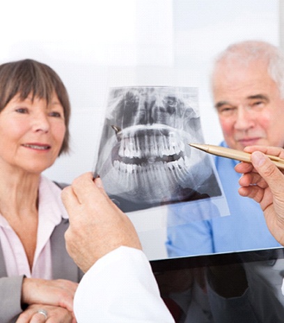 A dentist showing an older couple an X-ray.