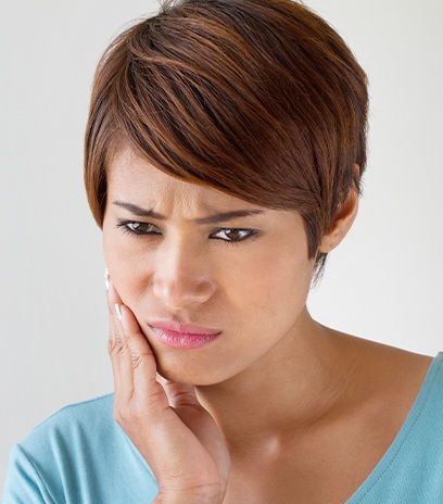 Woman in need of root canal therapy holding jaw in pain