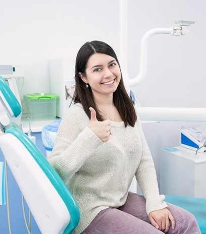 Woman giving thumbs up after root canal in Belmont, MA