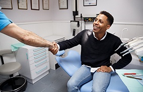 Male dental patient shaking dentist’s hand after root canal in Belmont, MA