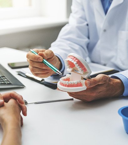 Belmont dentist showing patient model of teeth