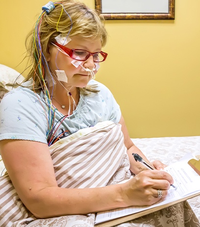 Woman covered in wires during sleep test