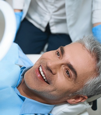 Man admiring new smile after getting veneers in Belmont, MA