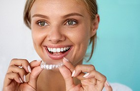 Woman about to wear tray for teeth whitening in Belmont, MA
