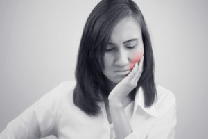 Woman with tooth pain holding her jaw