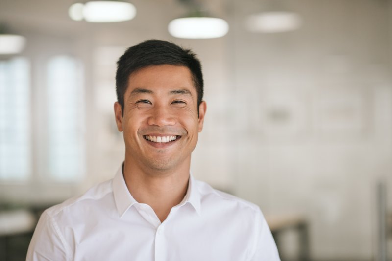 middle-aged person with dentures smiling